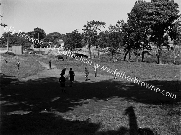 CHILDREN PLAYING CRICKET  BRIDGE IN BACKGROUND